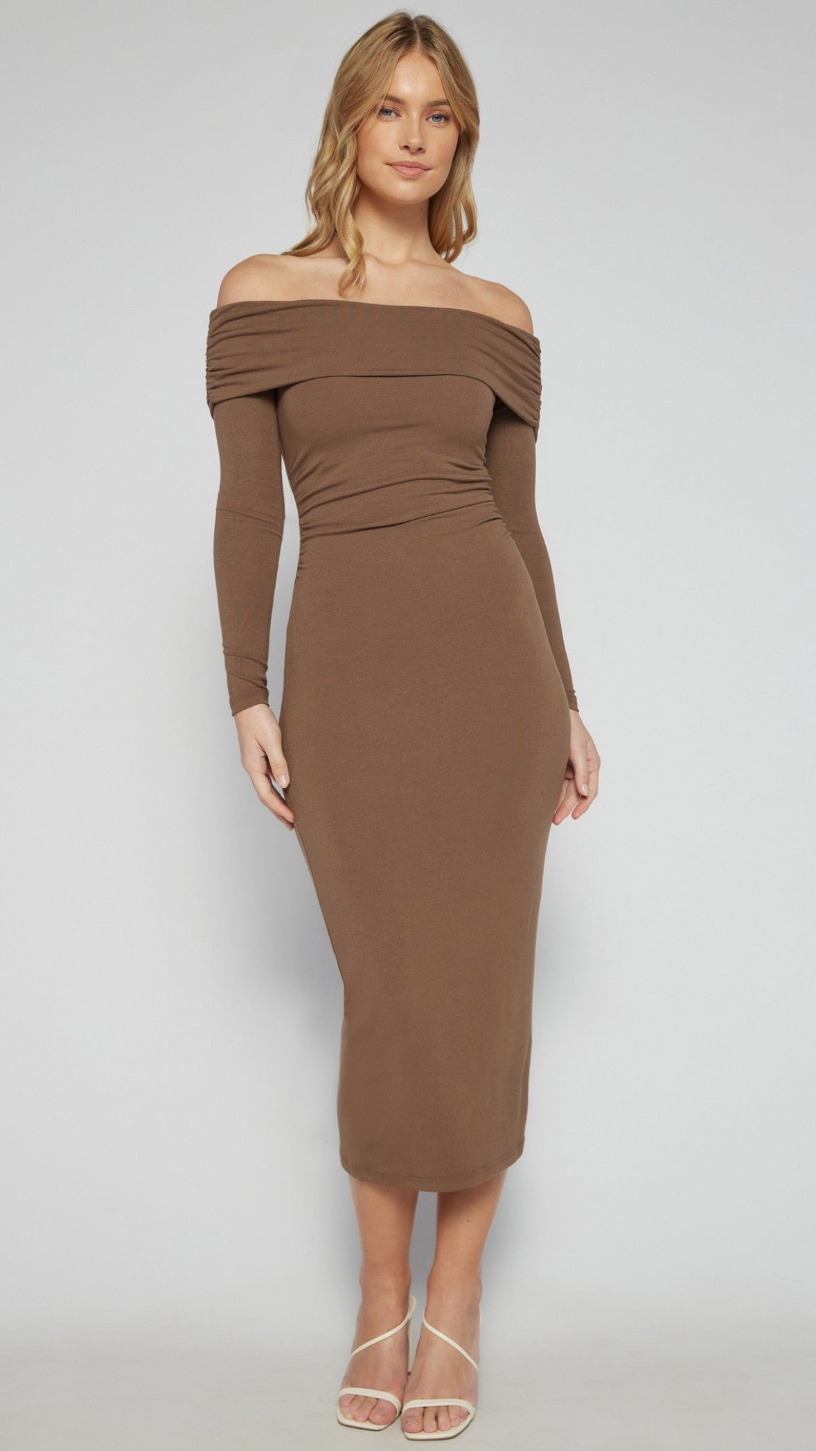 Front view of a model wearing The Alyssa Sculpted Fit Dress in brown, featuring an off-shoulder neckline and ruched detailing.