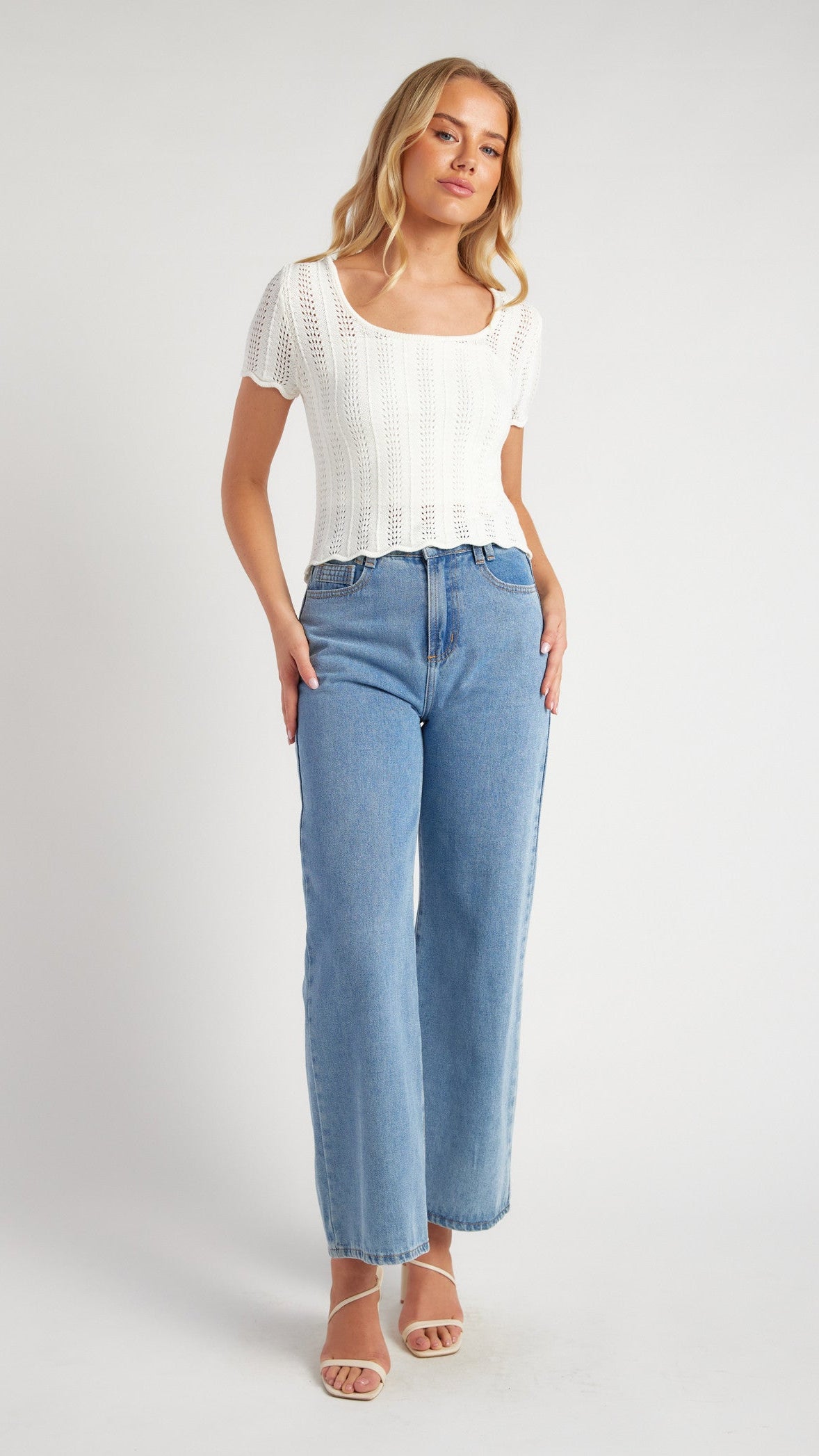 White crochet knit top with scallop hemline and singlet cami, paired with jeans.