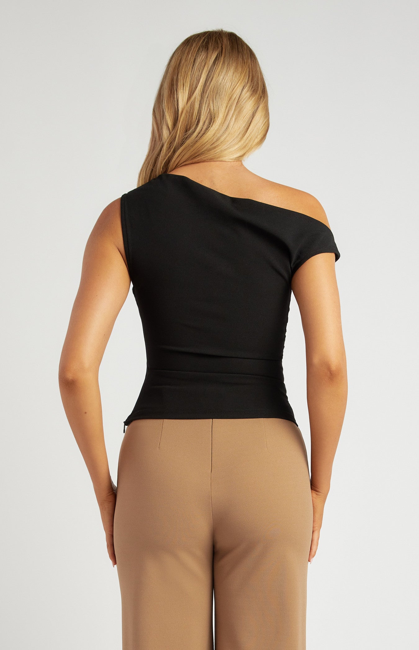 Back view of the black one-shoulder top with sleek stretch jersey fabrication.