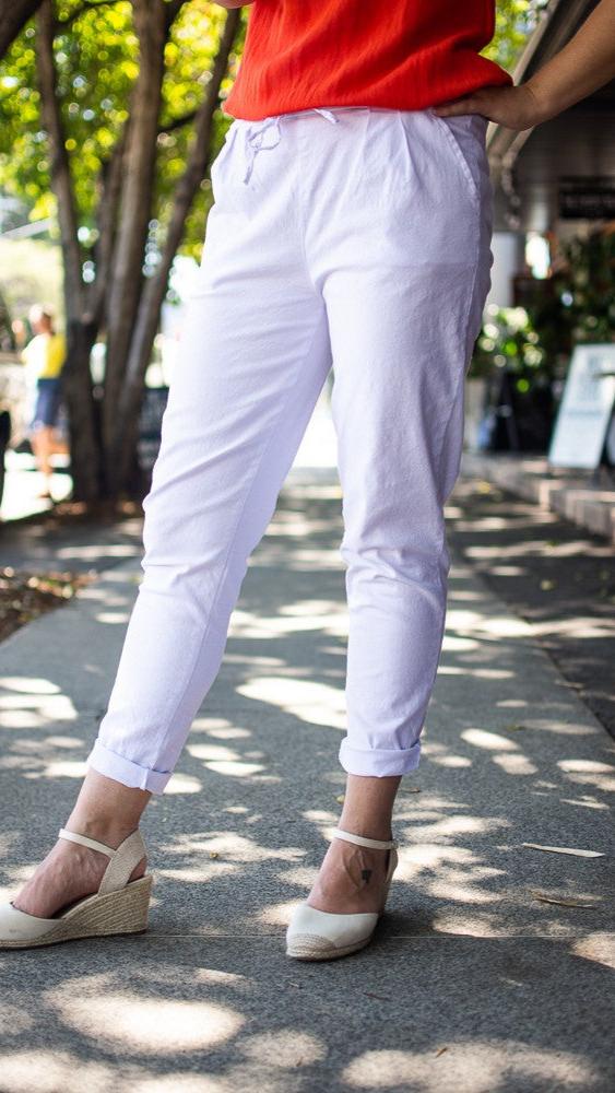 Sid view of white tapered linen pants styled with a red top - Eva Jean Collective